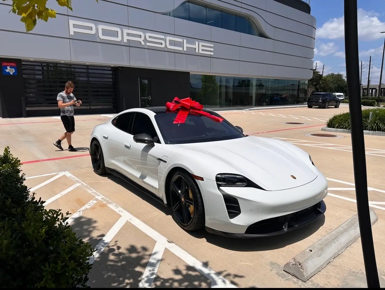 White Porsche Taycan delivered with a red bow